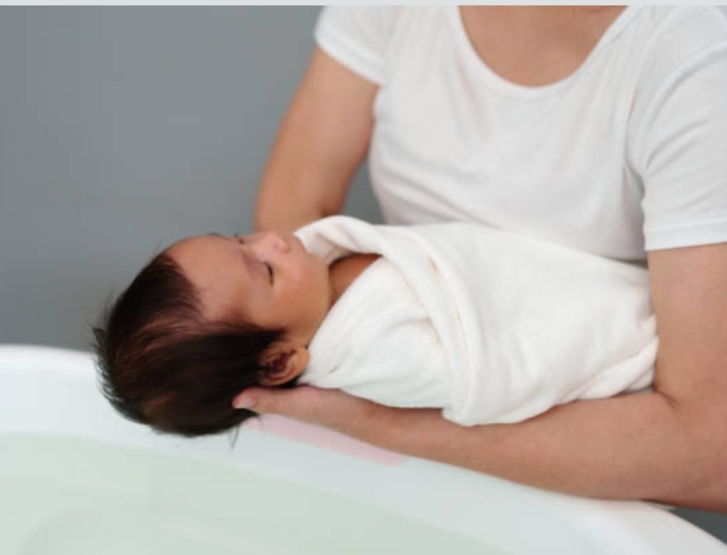 Bain enveloppé thérapeutique pour nourrisson dans un linge chaud et rassurant, dès les premiers jours — L’Immersion Originelle® — Maison Parent’aise & Bien Naître.